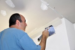 a contractor spackling drywall