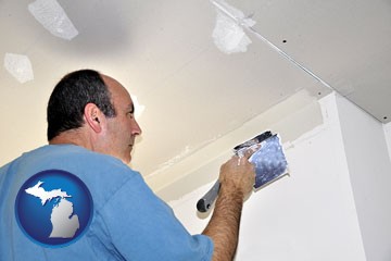a contractor spackling drywall - with Michigan icon