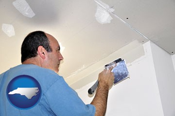 a contractor spackling drywall - with North Carolina icon