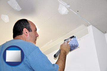 a contractor spackling drywall - with Wyoming icon